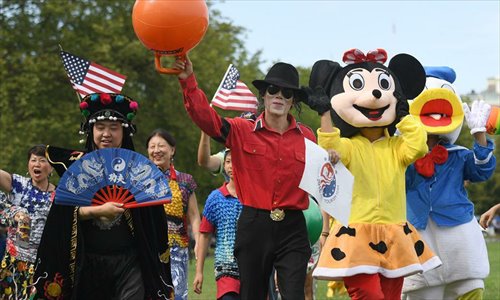 People dressed as Chinese traditional opera character, Michael Jackon, Mickey Mouse and Donald Duck attend a massive flash mob highlighting Chinese and U.S. cultural features in celebration of the 2016 China-U.S. Tourism Year on the Ellipse lawn in front of the White House, Washington D.C., the United States, Sept. 5, 2016.Photo:Xinhua