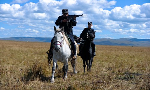 A mounted policeman aims his rifle. Photo: CFP