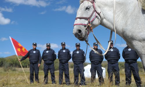 Policemen stand with a red flag. In the vast expanse of the grassland, it's easier to guide with bright colors. Photo: CFP