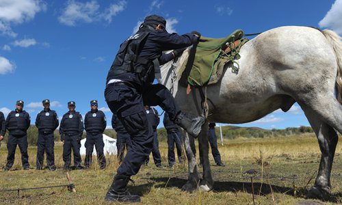 A policeman mounts his horse. Photo: CFP