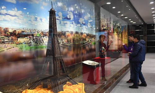 Spectators watch a replica of Eiffel Tower made of chocolate at the Museum of the Imperial Palace of 