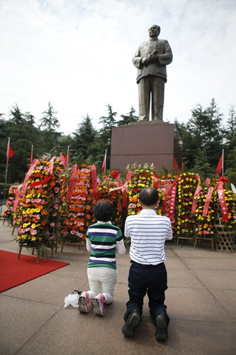 Two visitors kneel as they show their respects to Mao at the Mao Zedong Bronze Statue Square in Shaoshan on September 8.  Photo: Li Hao/GT