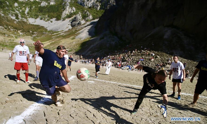 people play football on dried lake bottom in croatia