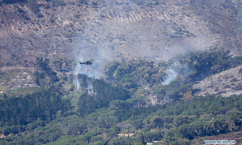 A helicopter flies to put out a wildfire near Vredehoek, Cape Town, South Africa, on April 20, 2021. The wildfire that broke out on South Africa's iconic Table Mountain on Sunday morning has been largely contained but the danger remains, the Western Cape provincial government said in a statement Tuesday.(Photo: Xinhua)