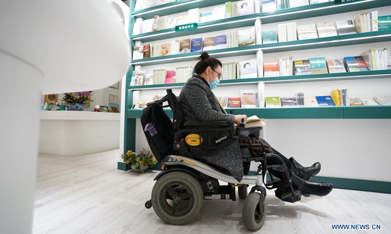 Disabled author Luo Yan browses a book at Shanyuan Book Chamber in Beijing, capital of China, April 14, 2021.Photo:Xinhua