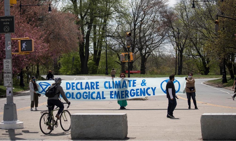 Activists hold a sign on Earth Day in front of Prospect Park in the Brooklyn borough of New York, the United States, on April 22, 2021.Photo:Xinhua