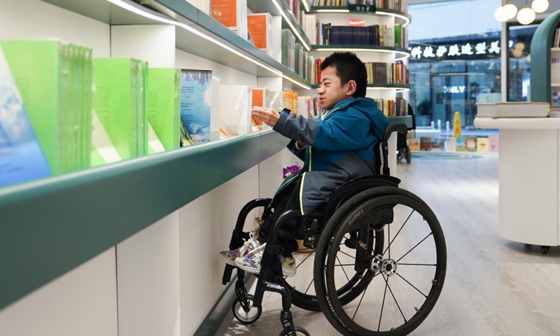 Liu Daming, an osteogenesis imperfecta patient and book author, visits Shanyuan Book Chamber in Beijing, capital of China, April 14, 2021.Photo:Xinhua