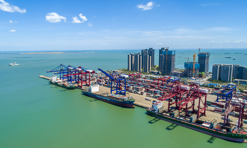 Ships load and unload containers at Haikou Port in South China's Hainan Province on Monday. As the main section of Haikou Port, the Xiuying Port can handle about 4.06 million tons of cargo annually, and about 800,000 units of 20-foot equivalent containers. In 2020, Hainan's foreign trade reached 93.3 billion yuan ($14.5 billion), up 3 percent year-on-year, per customs data. Photo: VCG