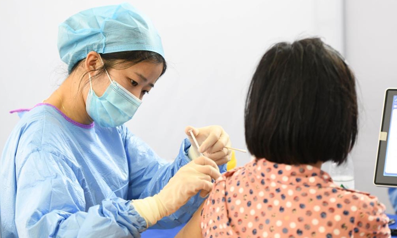 A woman receives a dose of COVID-19 vaccine at a vaccination site in Shushan District of Hefei, east China's Anhui Province, May 15, 2021. Since Friday morning, residents in Hefei have queued up at vaccination sites to receive COVID-19 vaccines. Some sites have prolonged their service time or even run around the clock.Photo:Xinhua