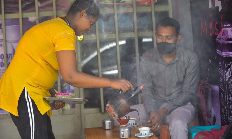 Kisanet Birhane (L), a street vendor who sells coffee goes about her work in Addis Ababa, capital of Ethiopia, on May 14, 2021.(Photo:Xinhua)