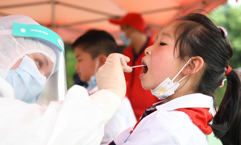 A medical worker collects a swab sample of a student for nucleic acid testing at a primary school in Lu'an, east China's Anhui Province, May 22, 2021.Photo:Xinhua