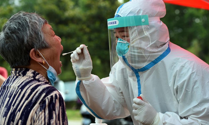 A medical worker collects a swab sample of a resident for nucleic acid testing at a community in Lu'an, east China's Anhui Province, May 22, 2021.Photo:Xinhua