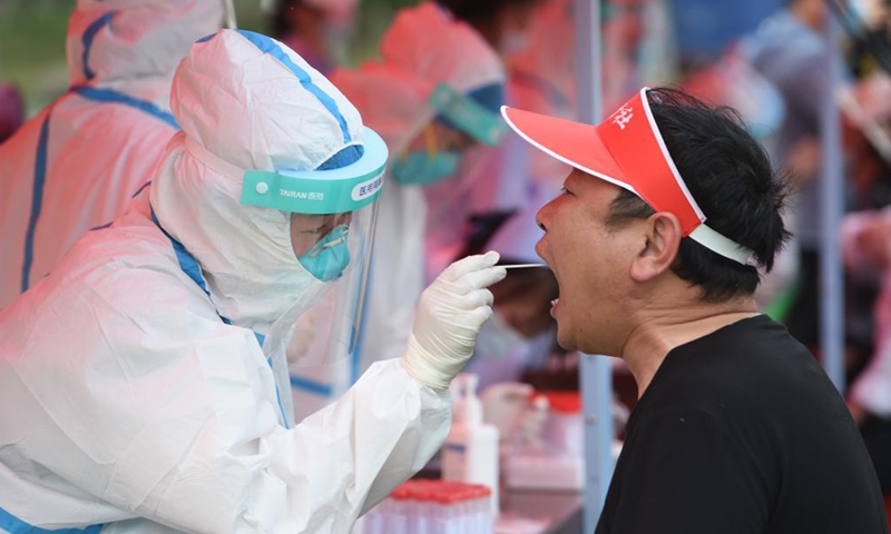 A medical worker collects a swab sample of a resident for nucleic acid testing at a community in Lu'an, east China's Anhui Province, May 22, 2021.Photo:Xinhua