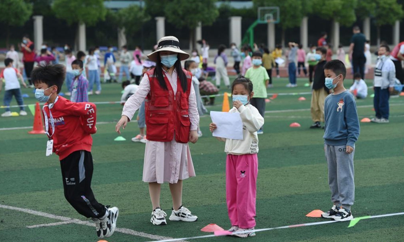 Students queue up to take swab sample for nucleic acid testing at a primary school in Lu'an, east China's Anhui Province, May 22, 2021.Photo:Xinhua