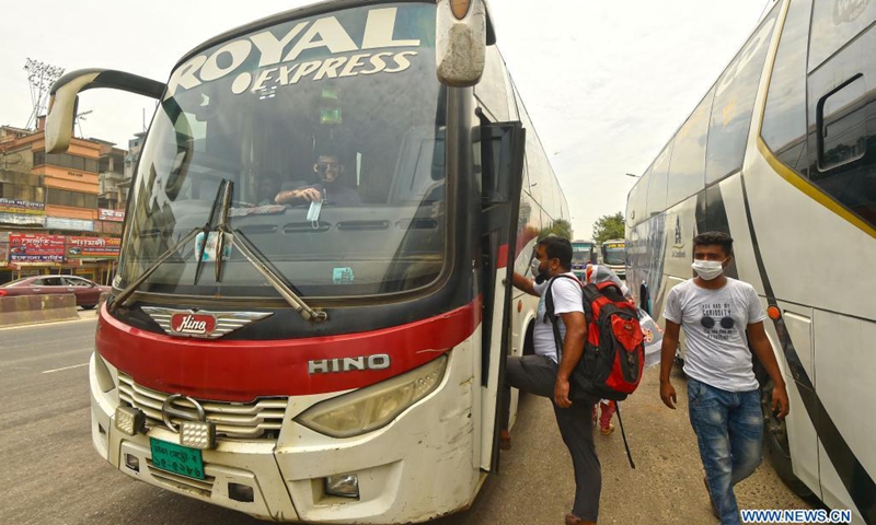 A passenger boards a bus at a terminal in Dhaka, Bangladesh on May 24, 2021. After a nearly seven-week suspension amid the COVID-19 lockdown, long-route bus, train and ferry services in Bangladesh resumed operations on Monday as the government eased pandemic restrictions.(Photo: Xinhua)