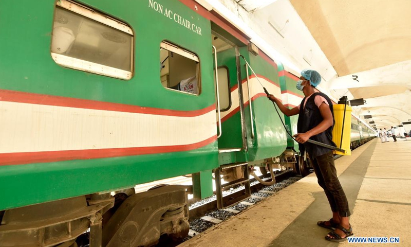 A worker sprays disinfectant to a train at a terminal in Dhaka, Bangladesh on May 24, 2021. After a nearly seven-week suspension amid the COVID-19 lockdown, long-route bus, train and ferry services in Bangladesh resumed operations on Monday as the government eased pandemic restrictions.(Photo: Xinhua)