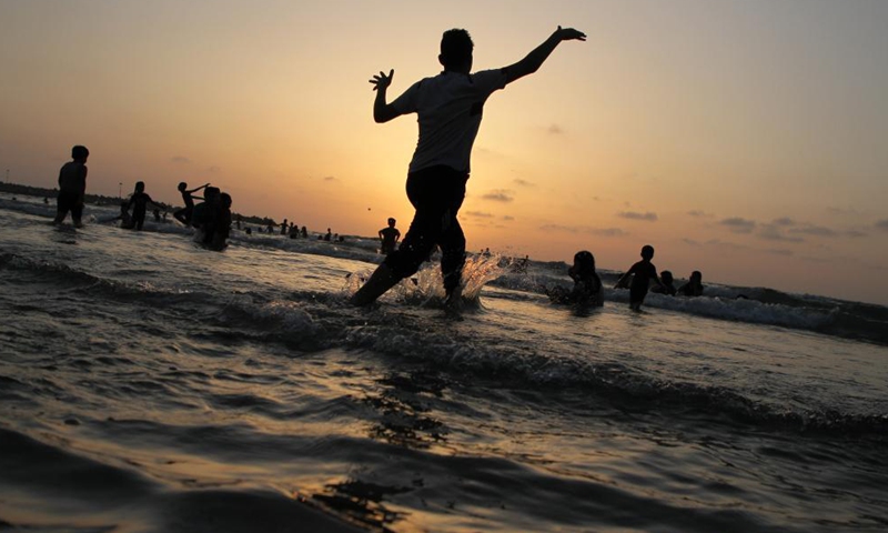 Palestinians enjoy themselves on a beach by the Mediterranean Sea off Gaza coast in Gaza City, on May 28, 2021.Photo:Xinhua