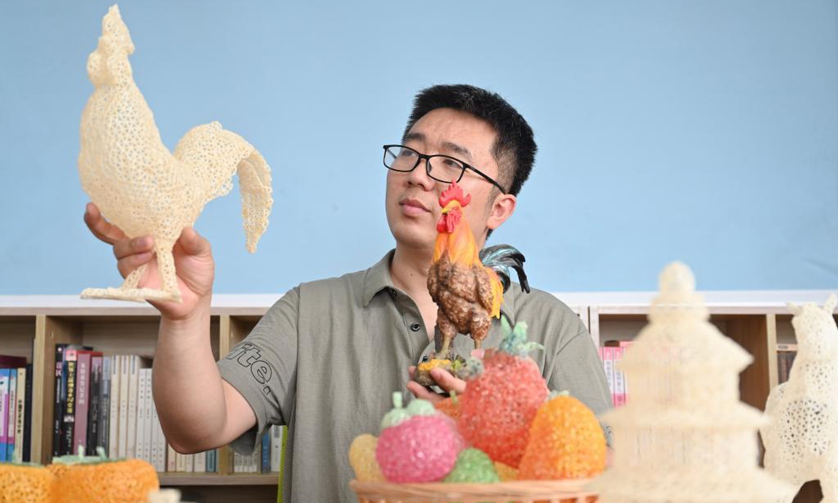 Chen Guorui shows a Gaolou rice craftwork resembling a cock in Gaolou Village, Fuzhou City of southeast China's Fujian Province, May 21, 2021. (Xinhua/Song Weiwei)