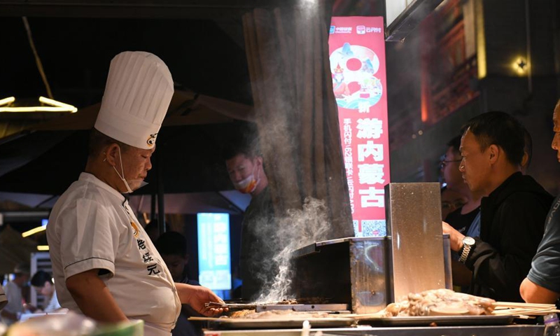 A cook grills lamb skewers in Hohhot, north China's Inner Mongolia Autonomous Region, June 10, 2021. Various activities such as appreciating traditional music and tasting local food are held here to promote tourism.   Photo: Xinhua