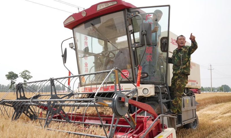 Local farmer Su Chuan (R) talks with his colleague about harvesting in a wheat field in Nanhe District of Xingtai, north China's Hebei Province, June 8, 2021. (Xinhua/Jin Haoyuan)