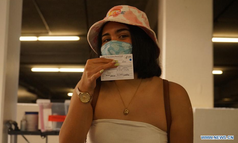 A woman shows the COVID-19 vaccination record card at the Universal Studios Hollywood in Los Angeles, California, the United States, June 18, 2021. California has launched a digital platform through which local residents could get access to their COVID-19 vaccine records.Photo:Xinhua