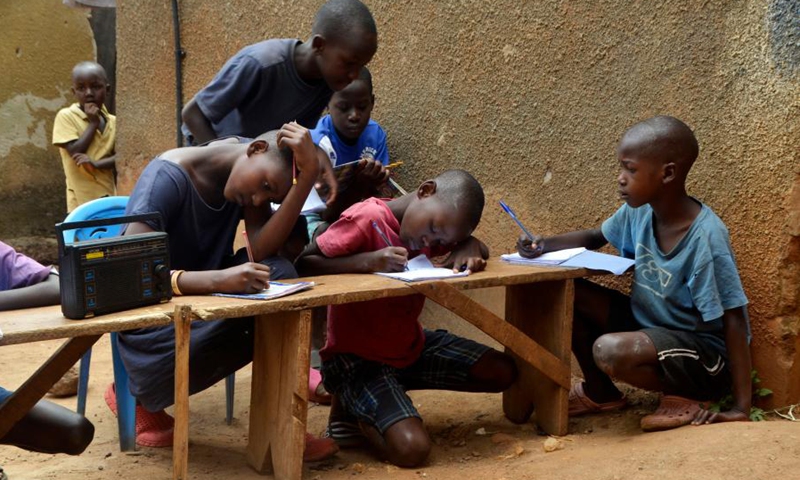 Children listen to a radio program in Kampala, Uganda, June 14, 2021.(Photo: Xinhua)