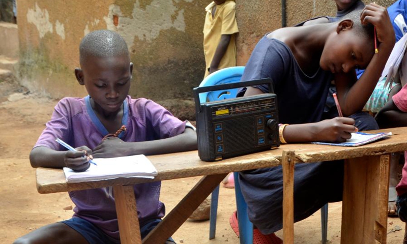 Children listen to a radio program in Kampala, Uganda, June 14, 2021.(Photo: Xinhua)