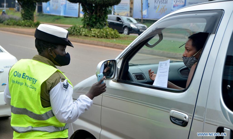 A police officer wearing a face mask talks to a woman in a vehicle in Kampala, Uganda, on July 4, 2021. Uganda has introduced new penalties for offenders of the country's COVID-19 prevention procedures. A statutory instrument dubbed Public Health (Control of COVID-19) rules 2021, signed by Health Minister Ruth Aceng, said that if one is found guilty of not wearing a facial mask while in public places, he or she will face a jail term of two months.(Photo: Xinhua)