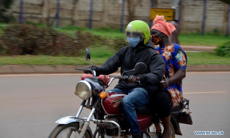 People wearing face masks ride a motorcycle in Kampala, Uganda, on July 4, 2021. Uganda has introduced new penalties for offenders of the country's COVID-19 prevention procedures. A statutory instrument dubbed Public Health (Control of COVID-19) rules 2021, signed by Health Minister Ruth Aceng, said that if one is found guilty of not wearing a facial mask while in public places, he or she will face a jail term of two months.(Photo: Xinhua)