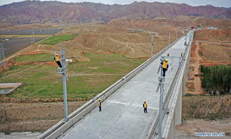 Aerial photo taken on July 10, 2021 shows railway staff members working at the Zhongwei section of the Zhongwei-Lanzhou high-speed rail line, in northwest China's Ningxia Hui Autonomous Region. A major high-speed railway in northwest China has entered a key phase recently, where the construction of overhead contact system has been rolled out.(Photo: Xinhua)