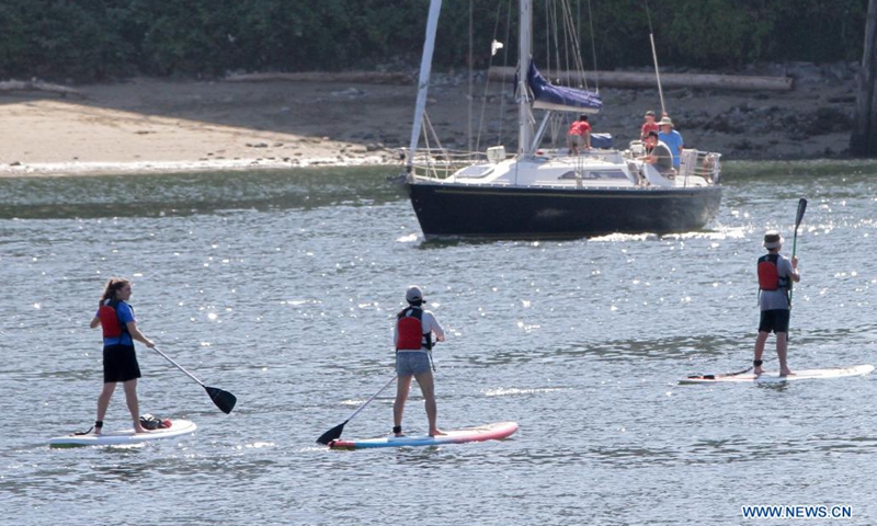 People play standup paddling in waters in Vancouver, British Columbia, Canada, on July 13, 2021. As the summer boating season ramps up and more new boaters are sharing the waterways, the Port of Vancouver reminds people it's critical time to follow the safety practices and measures to ensure everyone's safety on waterways.(Photo: Xinhua)