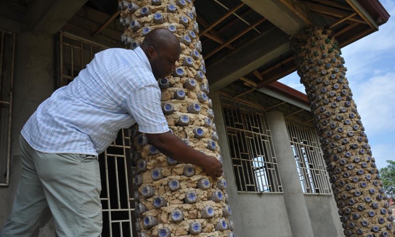 Martial Zohoungbogbo shows recycled plastic bottles filled with soil, which are used as bricks for building a community library, in Accra, Ghana, on June 24, 2021.(Photo: Xinhua)