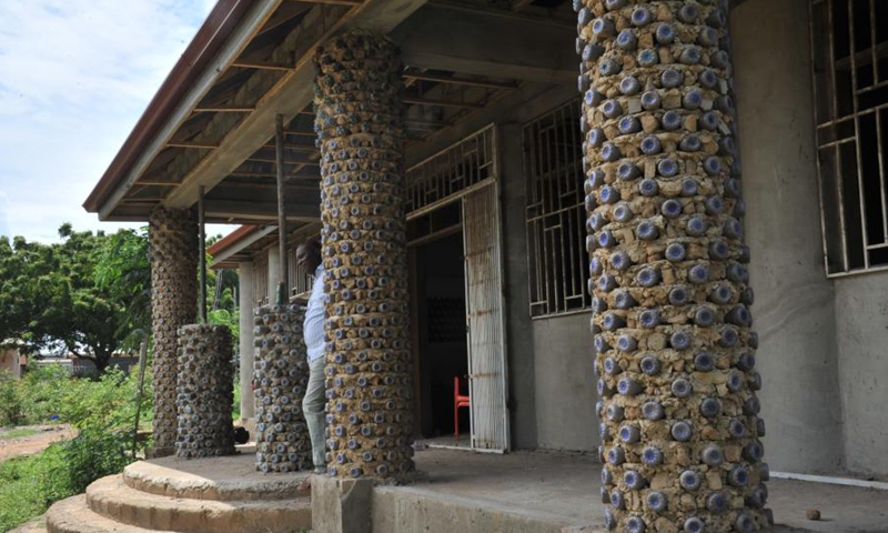 Martial Zohoungbogbo stands in front of the community library he built with recycled plastic bottles filled with soil in Accra, Ghana, on June 24, 2021.(Photo: Xinhua)