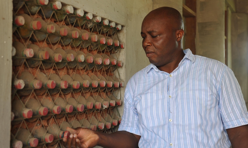 Martial Zohoungbogbo shows recycled plastic bottles filled with soil, which are used as bricks for building a community library, in Accra, Ghana, on June 24, 2021.(Photo: Xinhua)