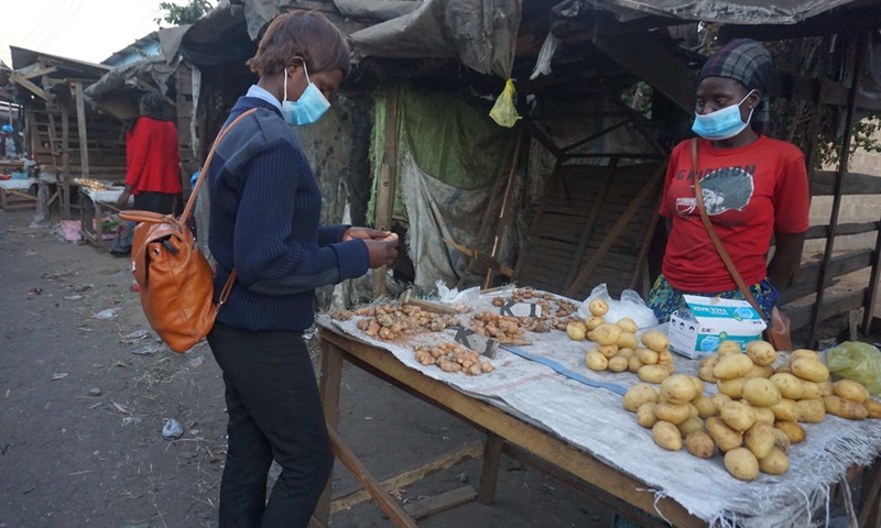 Naomi Kakoma (R), a 27-year-old trader at Lupili market, sells fresh ginger in Lusaka, Zambia, on June 27, 2021.(Photo: Xinhua)