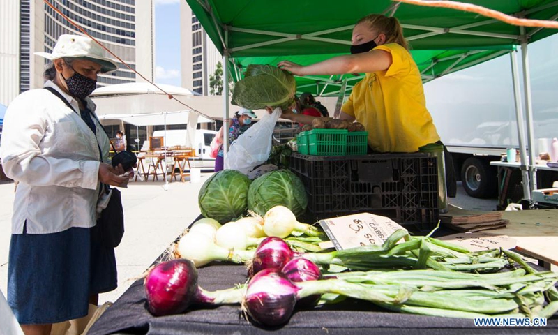 A woman wearing a face mask shops at Nathan Phillips Square Farmers' Market in Toronto, Canada, on July 21, 2021. With fresh fruit, vegetables, honey, maple syrup and flowers, the market opens every Wednesday from May 26 to Oct. 13 this year. (Photo: Xinhua)