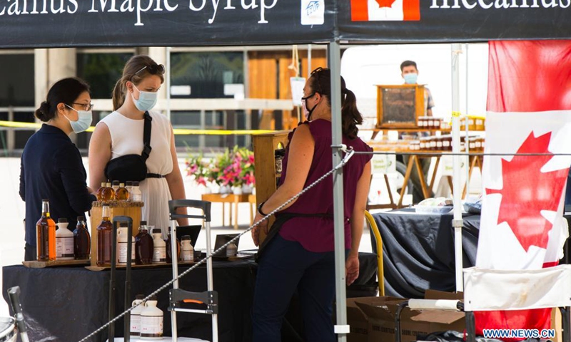 People wearing face masks shop at Nathan Phillips Square Farmers' Market in Toronto, Canada, on July 21, 2021. With fresh fruit, vegetables, honey, maple syrup and flowers, the market opens every Wednesday from May 26 to Oct. 13 this year.(Photo: Xinhua)