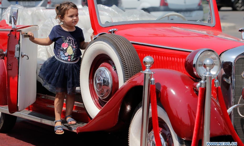 A girl is seen in a vintage car during the Old Cars Show 2021 organized by Romania's Vintage Vehicle Club in Bucharest, Romania, July 31, 2021.(Photo: Xinhua)