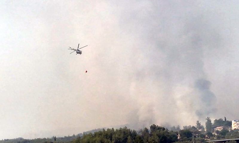 A firefighting helicopter is seen fighting a forest fire near the town of Manavgat, east of the resort city of Antalya, Turkey, July 31, 2021.(Photo: Xinhua)