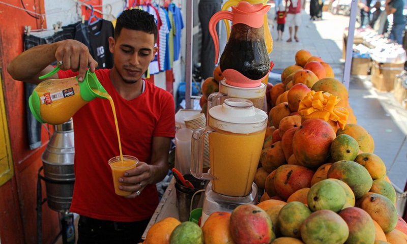 A Palestinian street food vendor makes mango juice in Gaza City on Aug. 2, 2021.(Photo: Xinhua)