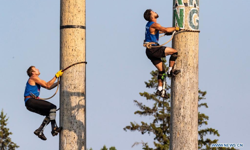 Participants compete in climbing during the 61st Lumberjack World Championships in Hayward, Wisconsin, the United States, on July 31, 2021. The championships held here showcased lumberjacks and lumberjills competing in sawing, chopping, speed climbing, log rolling, and boom-running.(Photo: Xinhua)