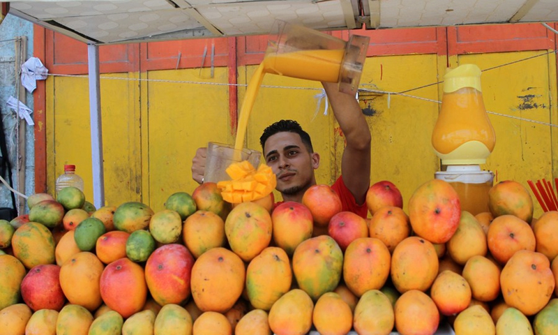 A Palestinian street food vendor makes mango juice in Gaza City on Aug. 2, 2021.(Photo: Xinhua)