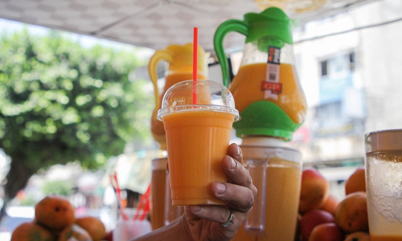 A Palestinian street food vendor makes mango juice in Gaza City on Aug. 2, 2021.(Photo: Xinhua)