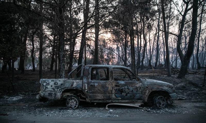 A burned car is seen after a forest fire raged in Varybobi, a northern suburb of Athens, Greece, Aug. 4, 2021.(Photo: Xinhua)