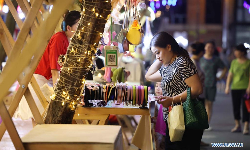 People shop at the Yangtze River 180 art district in Hefei City of east China's Anhui Province, Aug. 7, 2021. Transformed from old factory buildings, the Yangtze River 180 art district is now a cultural and creative industry park, which provides the citizens with space for recreation.(Photo: Xinhua)