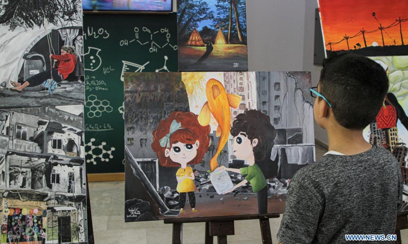 A visitor views artworks made by Palestinian children during an exhibition at Al-Qattan Center for the Child, in Gaza City, Aug. 8, 2021. About 120 children participated in the exhibition with their artworks.(Photo: Xinhua)