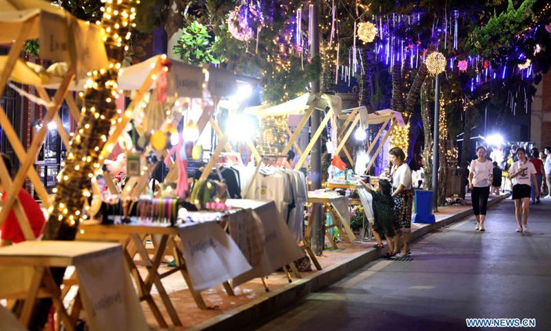 People shop at the Yangtze River 180 art district in Hefei City of east China's Anhui Province, Aug. 7, 2021. Transformed from old factory buildings, the Yangtze River 180 art district is now a cultural and creative industry park, which provides the citizens with space for recreation. (Photo: Xinhua)