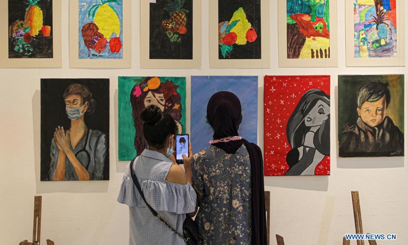 Visitors view artworks made by Palestinian children during an exhibition at Al-Qattan Center for the Child, in Gaza City, Aug. 8, 2021. About 120 children participated in the exhibition with their artworks.(Photo: Xinhua)