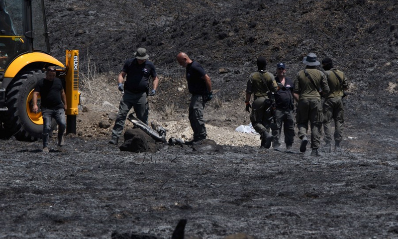 Israeli security members deal with the wreckage of a rocket launched from Lebanon into northern Israel, near the city of Kiryat Shmona, on Aug. 4, 2021.(Photo: Xinhua)