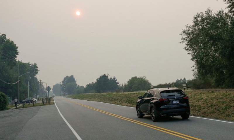 A car runs along a road under the smoky sky in Vancouver, British Columbia, Canada, Aug. 13, 2021. Vancouver was shrouded in smoke haze on Friday due to wildfires.Photo:Xinhua